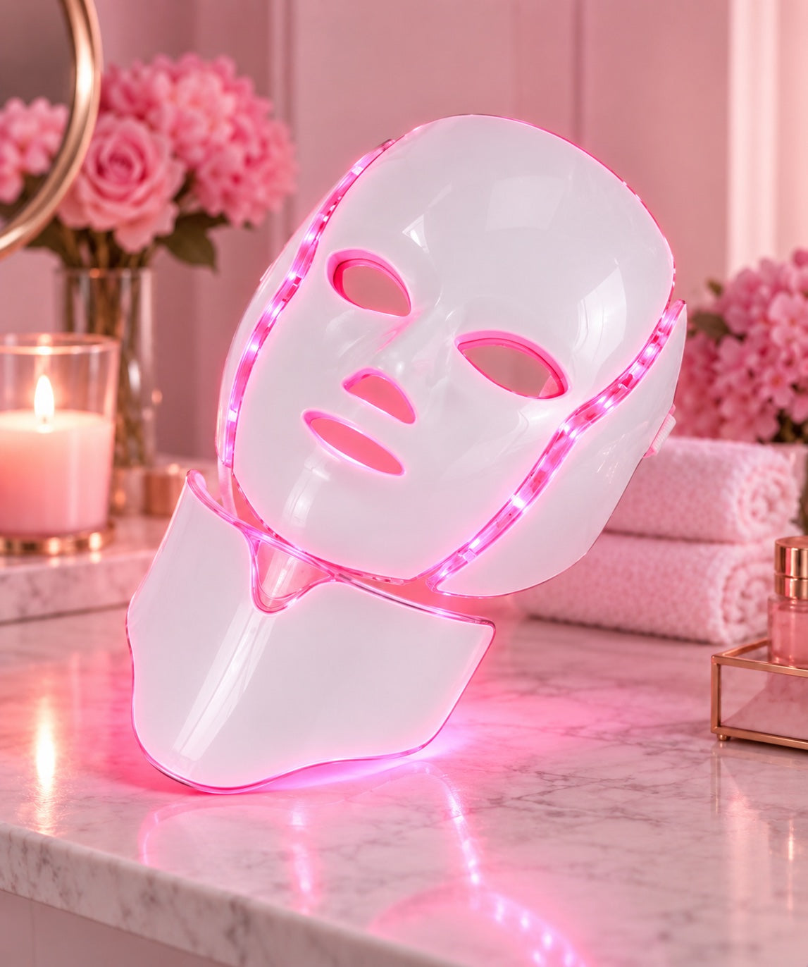 Pink LED face and neck mask on marble vanity